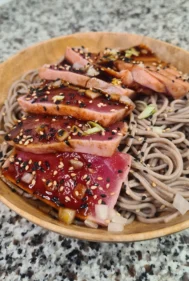 Presentación del plato con fideos soba fríos y tataki de atún rojo laminado